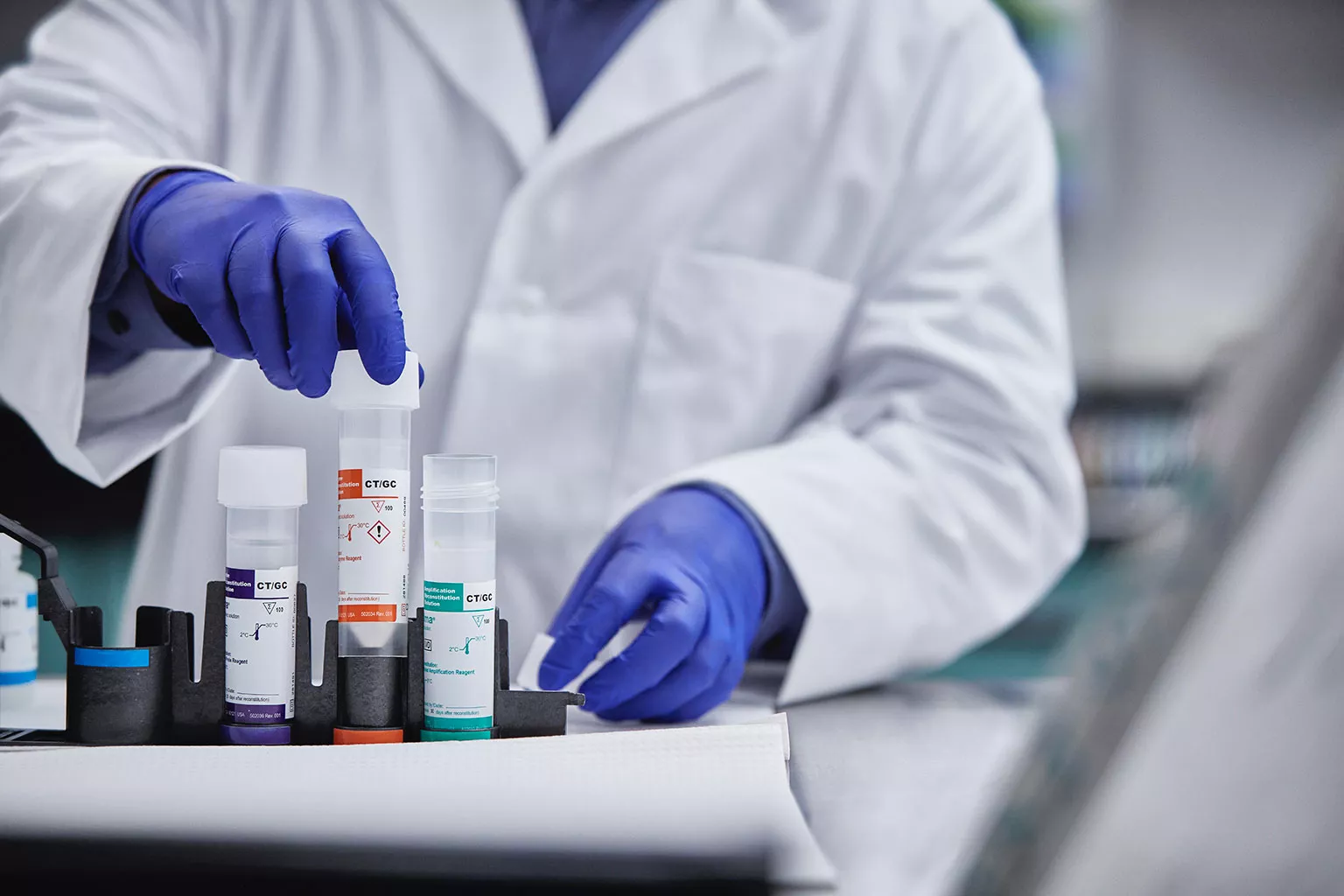 Labortechniker beim Anheben von Reagenzgefäßen in Laborumgebung.