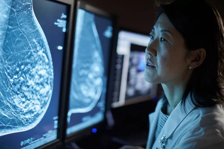 Medizinische Fachkraft beim Betrachten von Röntgenbildern auf Monitoren